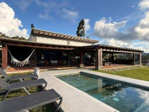 a house with a swimming pool and a pavilion at Casa Boutique Calima in Restrepo