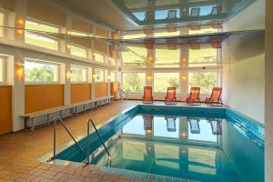 a swimming pool with chairs in a building at Landhotel Löwen Bernau in Bernau im Schwarzwald