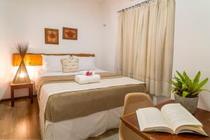 a bedroom with two beds and a table with an open book at Villa Água de Coco in Jericoacoara +84 photos