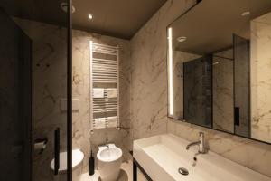 a bathroom with a sink and a toilet and a mirror at Joy 124 Hotel Milano in Milan
