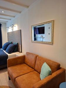 a living room with a couch and a mirror at Dulce Tierra - vakantiewoning in Zoutelande