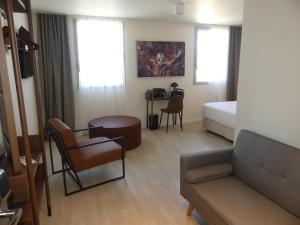 a hotel room with a couch and a bed and a table at Adonis le Castellet in Signes +82 photos