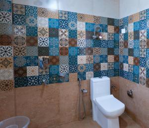 a bathroom with a toilet and tiles on the wall at Pinnacle view in Manāli