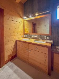 a bathroom with two sinks and a large mirror at Chalet Sainfoin in Verbier +33 photos