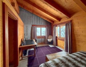 a room with a bed and a desk in a cabin at Chalet Sainfoin in Verbier