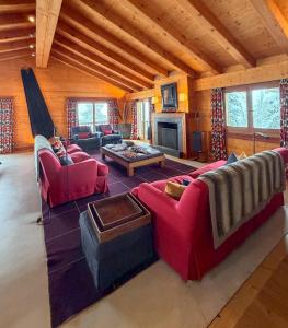 a large living room with red couches and a fireplace at Chalet Sainfoin in Verbier
