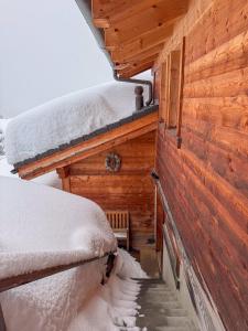 a cabin with snow on the roof and a staircase at Chalet Sainfoin in Verbier