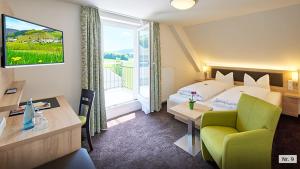 a hotel room with a bed and a desk and a room at Landhotel Löwen Bernau in Bernau im Schwarzwald +46 photos
