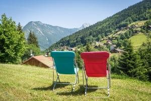 two chairs sitting on top of a grassy hill at Le Chalet des 3 Monts in Les Clefs +8 photos
