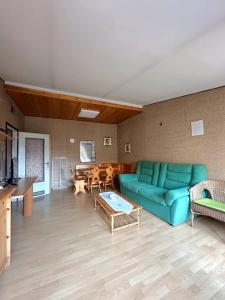 a living room with a blue couch and a table at Mansarda Belvedere in Margno