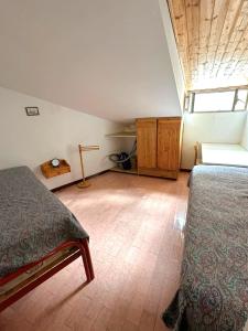 an attic bedroom with two beds and a window at Mansarda Belvedere in Margno