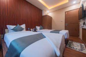 Hotel Nariyah في Dhungrebās: غرفة فندقية بسريرين وتلفزيون