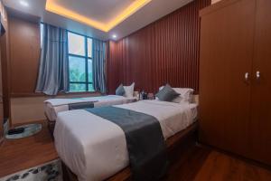 Hotel Nariyah في Dhungrebās: غرفة فندق بها سريران ونافذة