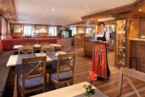 a woman is standing in a restaurant at Landhotel Löwen Bernau in Bernau im Schwarzwald