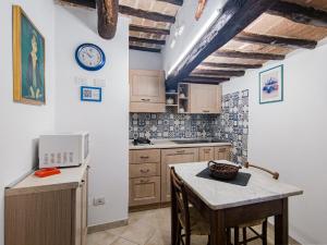 a kitchen with a table and a clock on the wall at B&B Siena In Centro - Diffuso in Siena +30 photos