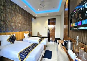 a hotel room with two beds and a tv at Hotel Heritage Inn in Balasore