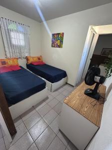 a bedroom with two beds and a table in it at Chalé Gratidão - Camping Carrion - ITU in Itu +24 photos