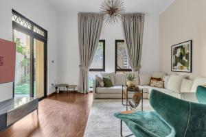 a living room with a white couch and chairs at GuestReady - 1BR | Private Garden - Burj Khalifa in Dubai +23 photos