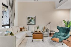 a living room with a white couch and a table at GuestReady - 1BR | Private Garden - Burj Khalifa in Dubai