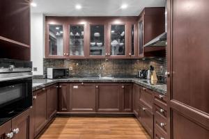 a kitchen with brown cabinets and a counter top at GuestReady - 1BR | Private Garden - Burj Khalifa in Dubai
