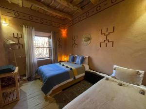 a bedroom with two beds and a window at Dar fatima in Midelt