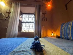 a bedroom with a blue bed with a window at Dar fatima in Midelt
