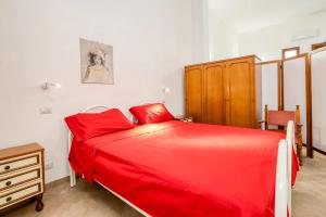 a bedroom with a red bed and a wooden cabinet at mono volta by salentolimit in Nardò
