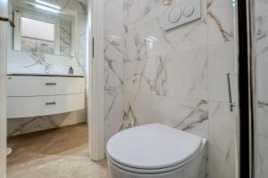 a bathroom with a toilet and a marble wall at mono volta by salentolimit in Nardò +9 photos