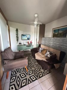 a living room with two couches and a tv at Chalé Gratidão - Camping Carrion - ITU in Itu
