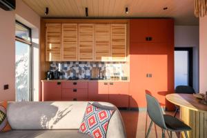 a kitchen with orange cabinets and a table and chairs at Emshir Villas in Krasnik