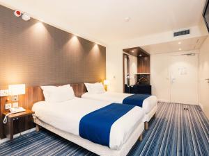 a hotel room with two beds and a bathroom at Holiday Inn Express Lille Centre by IHG in Lille