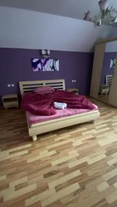 a bedroom with a bed with a purple wall at Cabana Iubirii in Ranca