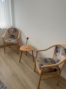 two chairs and a table with a vase with a flower on it at RadlStadl - Brauhaus und Hotel in Kaarst