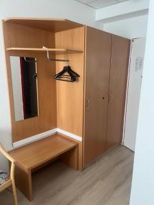 a closet with a mirror and a wooden cabinet at RadlStadl - Brauhaus und Hotel in Kaarst +2 photos