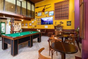 a pool table in a room with tables and chairs at Hotel Flat Petras Residence in Curitiba