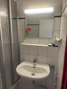 a bathroom with a white sink and a mirror at RadlStadl - Brauhaus und Hotel in Kaarst