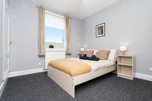 a white bedroom with a bed and a window at Ideal Work Stays 3BR 6 Guests Free Parking in Falkirk