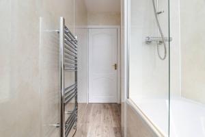 a bathroom with a shower and a glass door at Ideal Work Stays 3BR 6 Guests Free Parking in Falkirk +26 photos