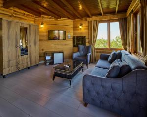 a living room with a blue couch and a fireplace at Sarı Köşk Hotel in Rize