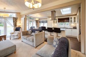 a living room with two couches and a kitchen at Sutton Lodge with Hot Tub in York