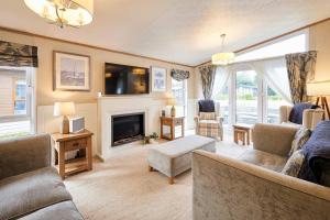 a living room with couches and a fireplace at Sutton Lodge with Hot Tub in York