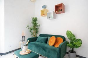 a green couch with orange pillows in a living room at Hotiday Rapallo Old Town in Rapallo