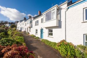 a row of white houses on a street at Little Chy an Mor in Coverack