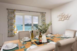 a dining room with a table with chairs and a window at Little Chy an Mor in Coverack