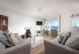 a living room with two couches and a fireplace at Little Chy an Mor in Coverack