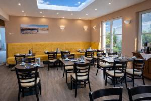 a restaurant with tables and chairs in a room with windows at Hotel zur Traube in Kühlungsborn