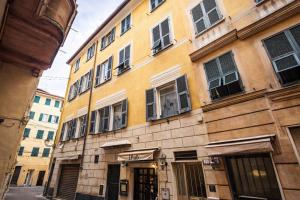 a yellow building with windows on a street at Hotiday Rapallo Old Town in Rapallo