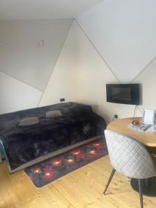 a bed in a room with a table and a chair at Shark in Liepāja
