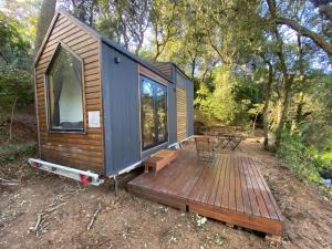 ein kleines Haus auf einem Holzdeck in der Unterkunft Tiny Clariana by Tiny Away in Palafolls