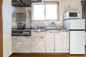 a kitchen with white appliances and a white refrigerator at 不二咲 in Fujiyoshida